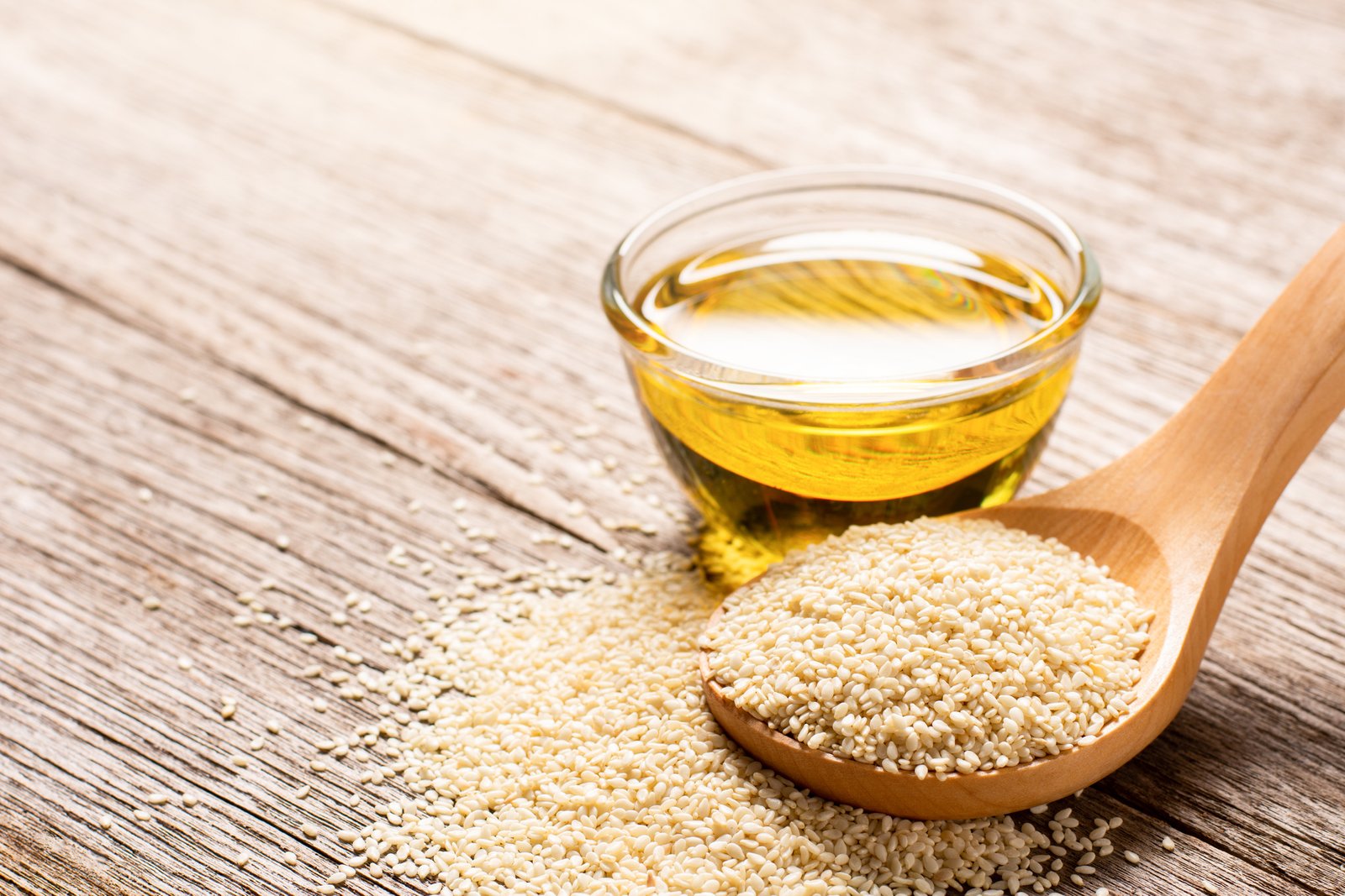 Sesame oil with seeds isolated on white background.